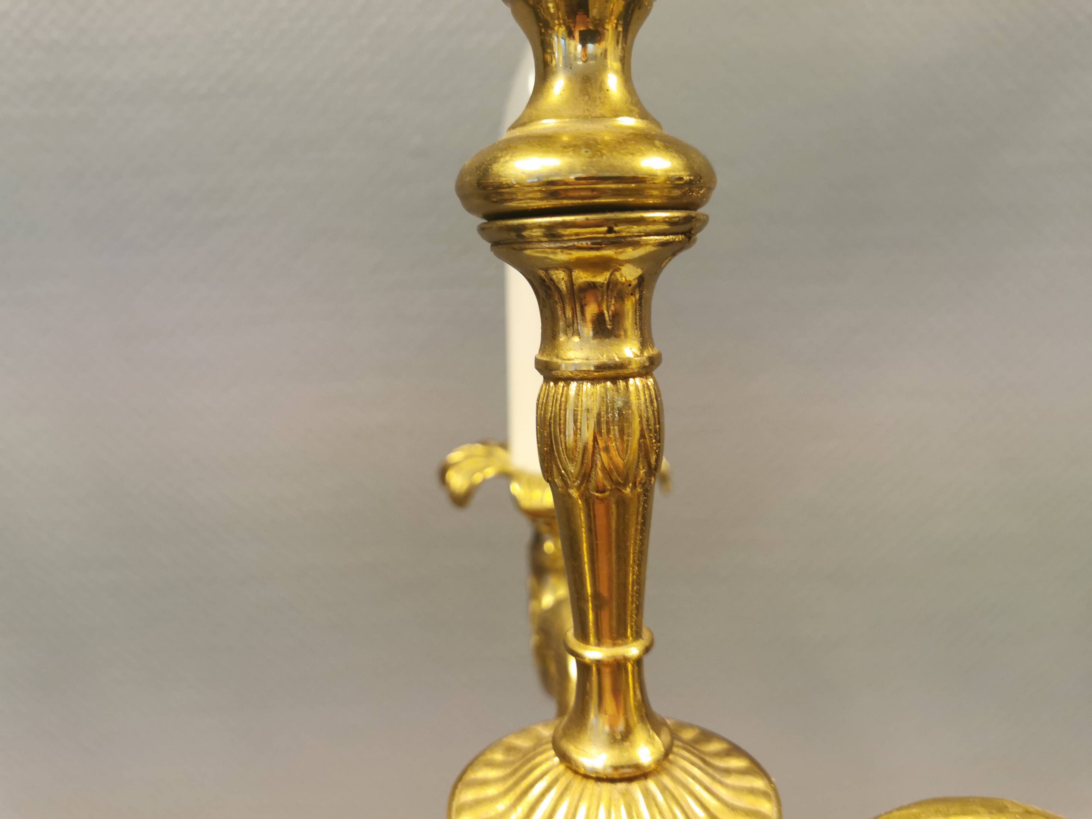 Older brass alloy chandelier with three light sources.