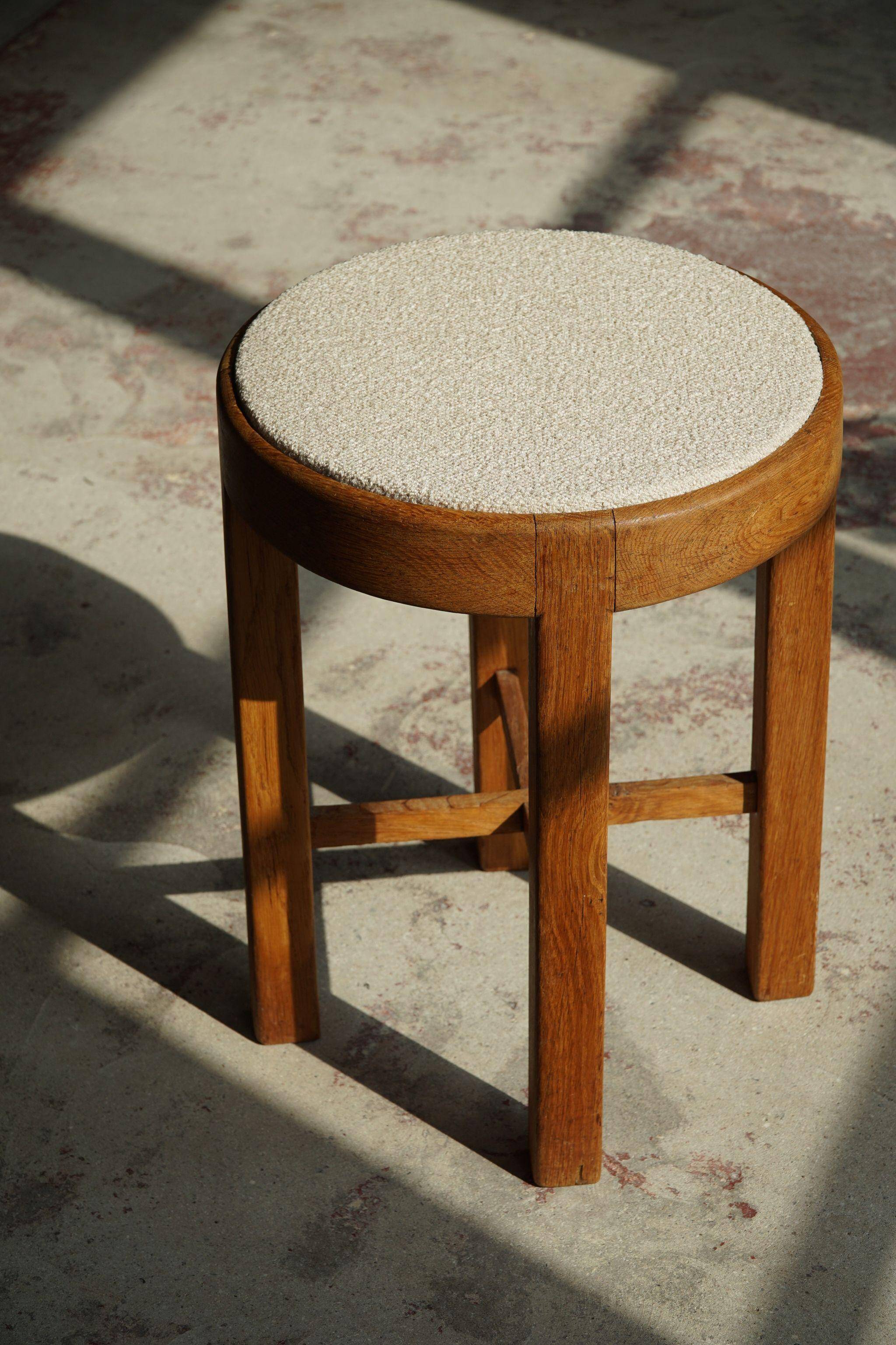 Mid-century Danish stool in oak, reupholstered in boucle wool, circa 1950.