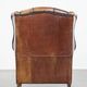 Cognac-colored sheep leather wingback chair finished with black piping