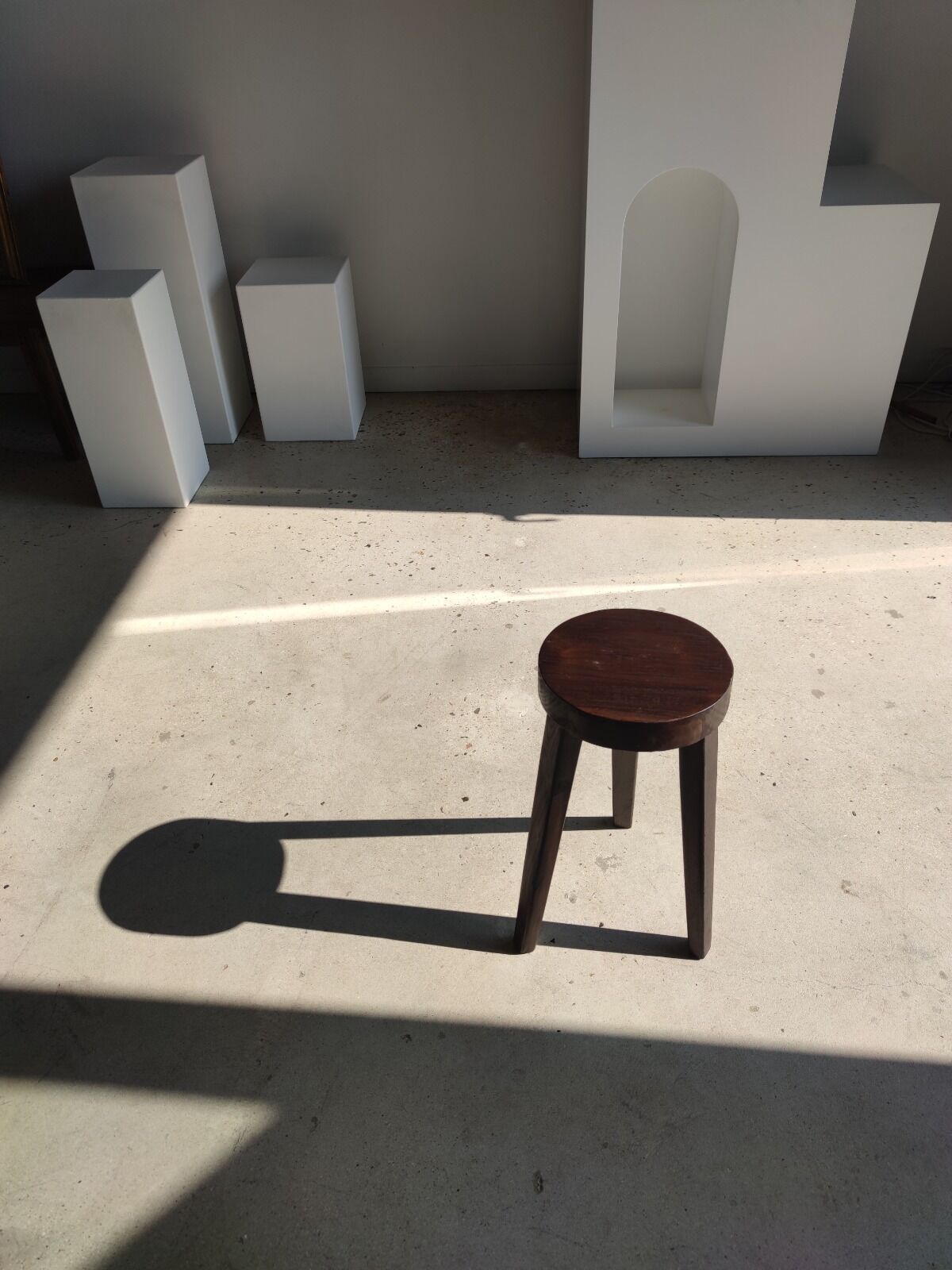 Small high tripod stool in brown solid wood