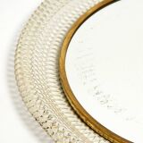 Mid Century Modern round wall mirror with a white expanded metal frame