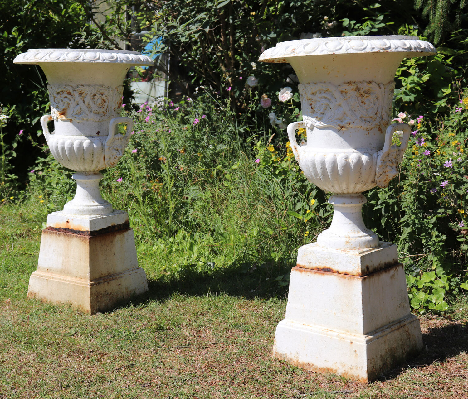 Pair of cast iron urns on plinth
