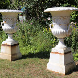Pair of cast iron urns on plinth