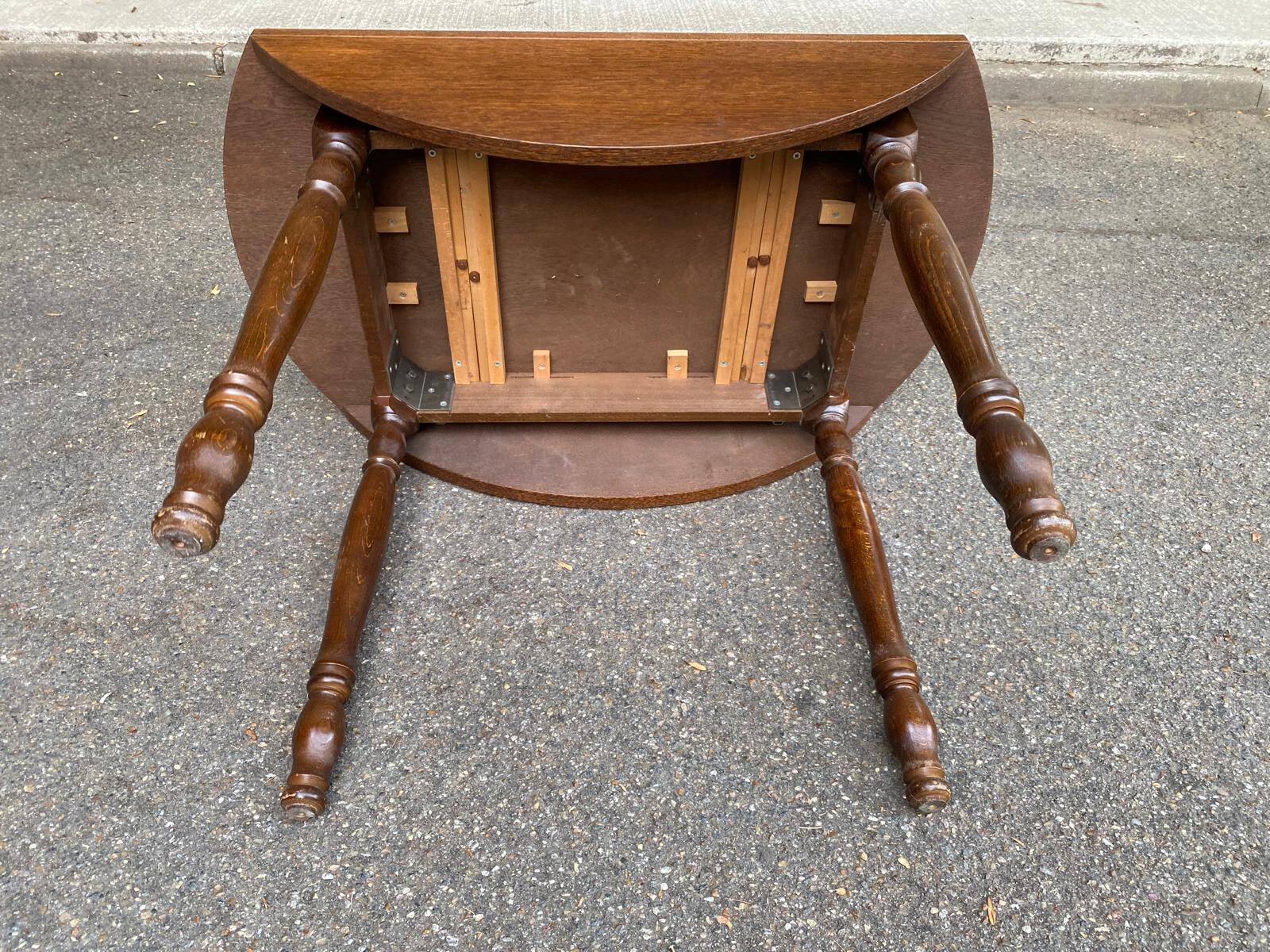 Round kitchen or dining table with extendable leaves in dark wood.