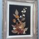 Wood frame dried flowers under glass, black background, vintage