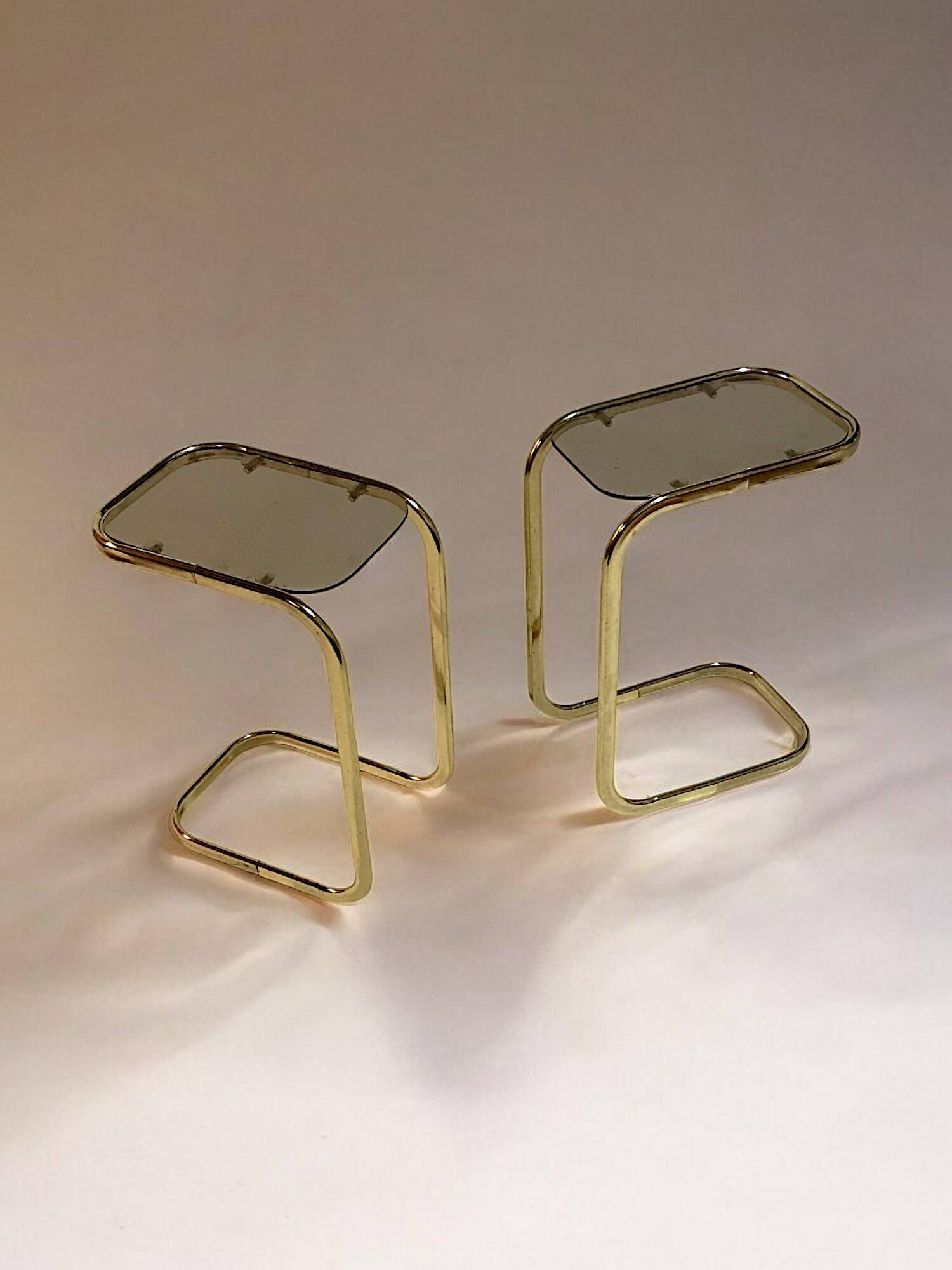 C. 1970 - Pair of side tables in gilded metal and smoked glass -
