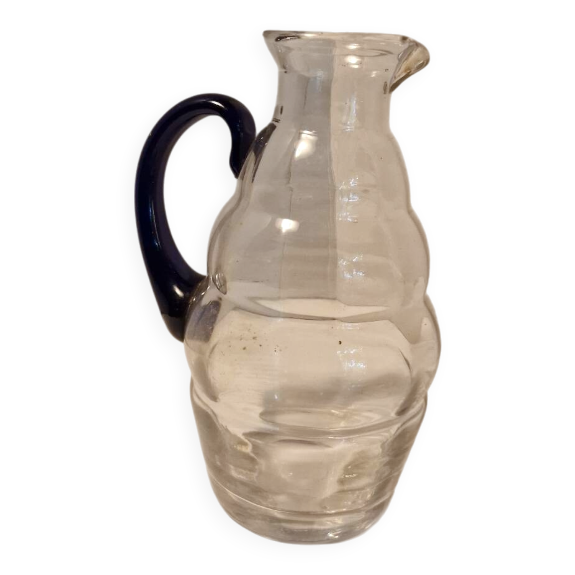 Glass carafe with wavy body and blue handle