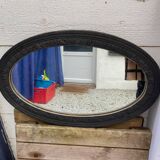 Old oval mirror with slate-coloured patina