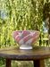 Old footed bowl in earthenware with pink decoration and defects.
