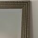 Textured embossed metal wall mirror with bevelled mirror.