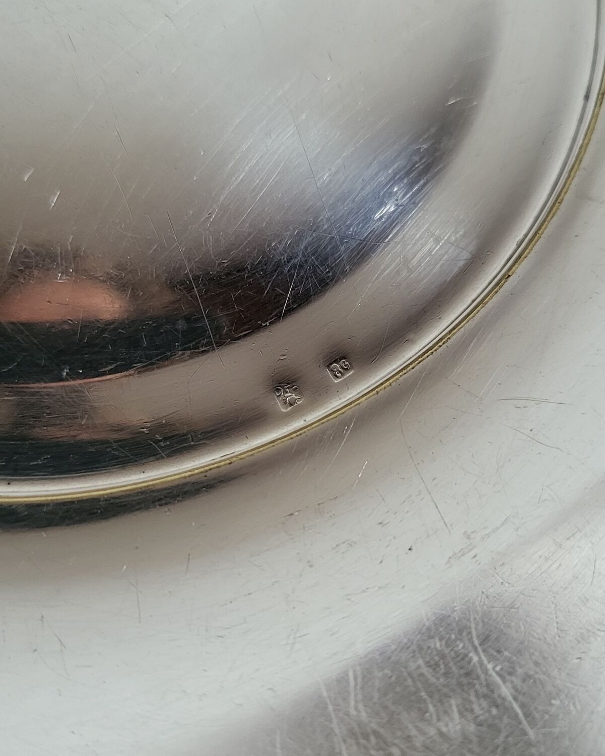 Shallow round metal plate with pearl bead decoration.