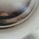 Shallow round metal plate with pearl bead decoration.