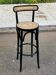 High bistro bar stool in curved black wood with a cane backrest.