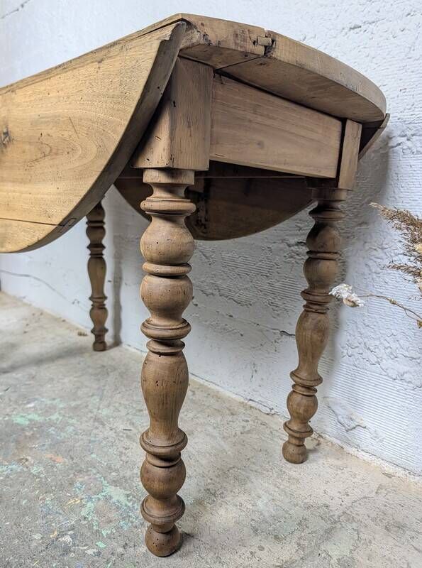 Antique wooden drop-leaf table with turned legs.