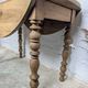 Antique wooden drop-leaf table with turned legs.