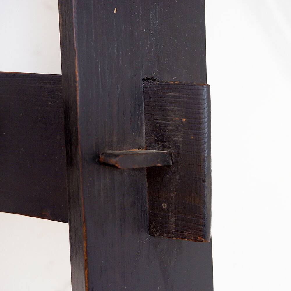 Vintage black-stained wooden tripod stool with mortise joints.