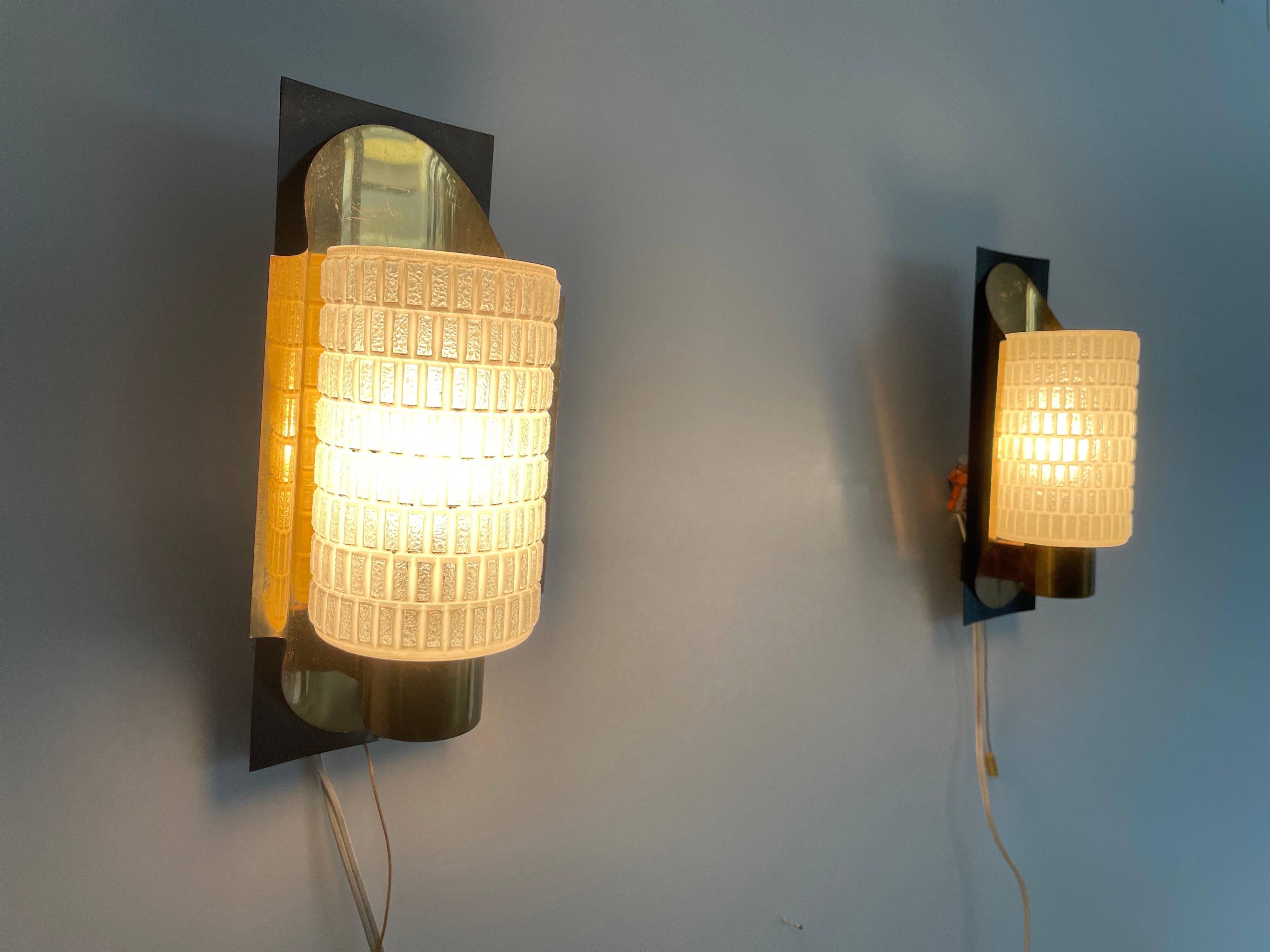 Mid-century pair of wall sconces in textured glass and brass, 1950s, Germany.