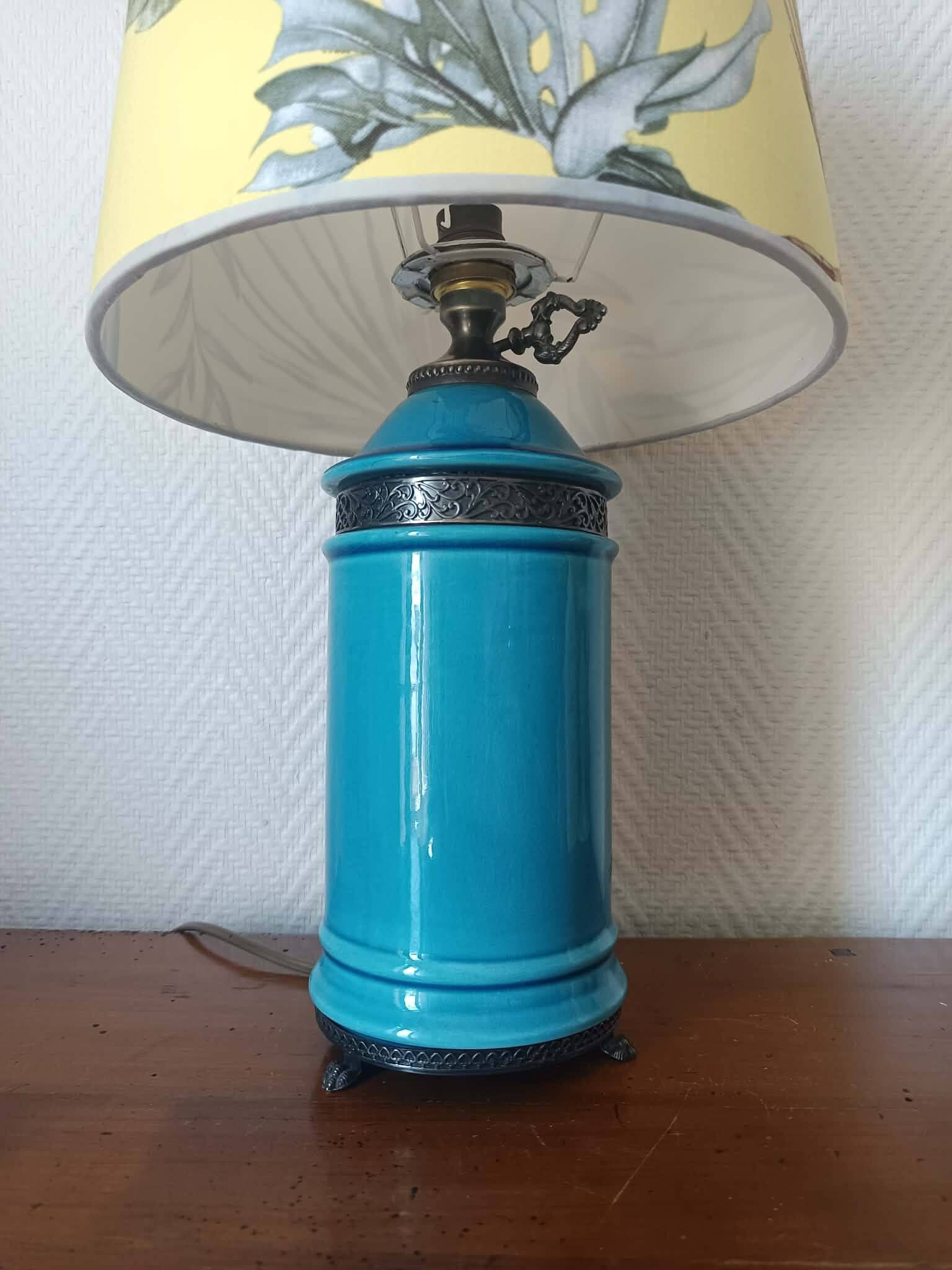 Blue ceramic lamp with claw feet and foliage lampshade.
