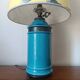 Blue ceramic lamp with claw feet and foliage lampshade.
