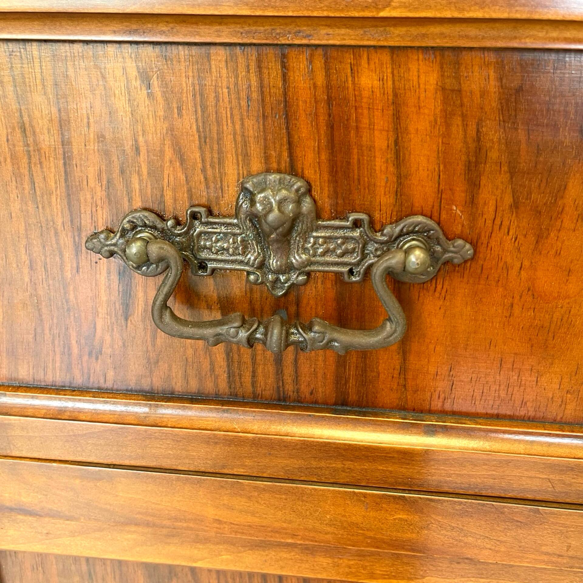 Antique walnut commode with bronze handles in the shape of a lion's mask,