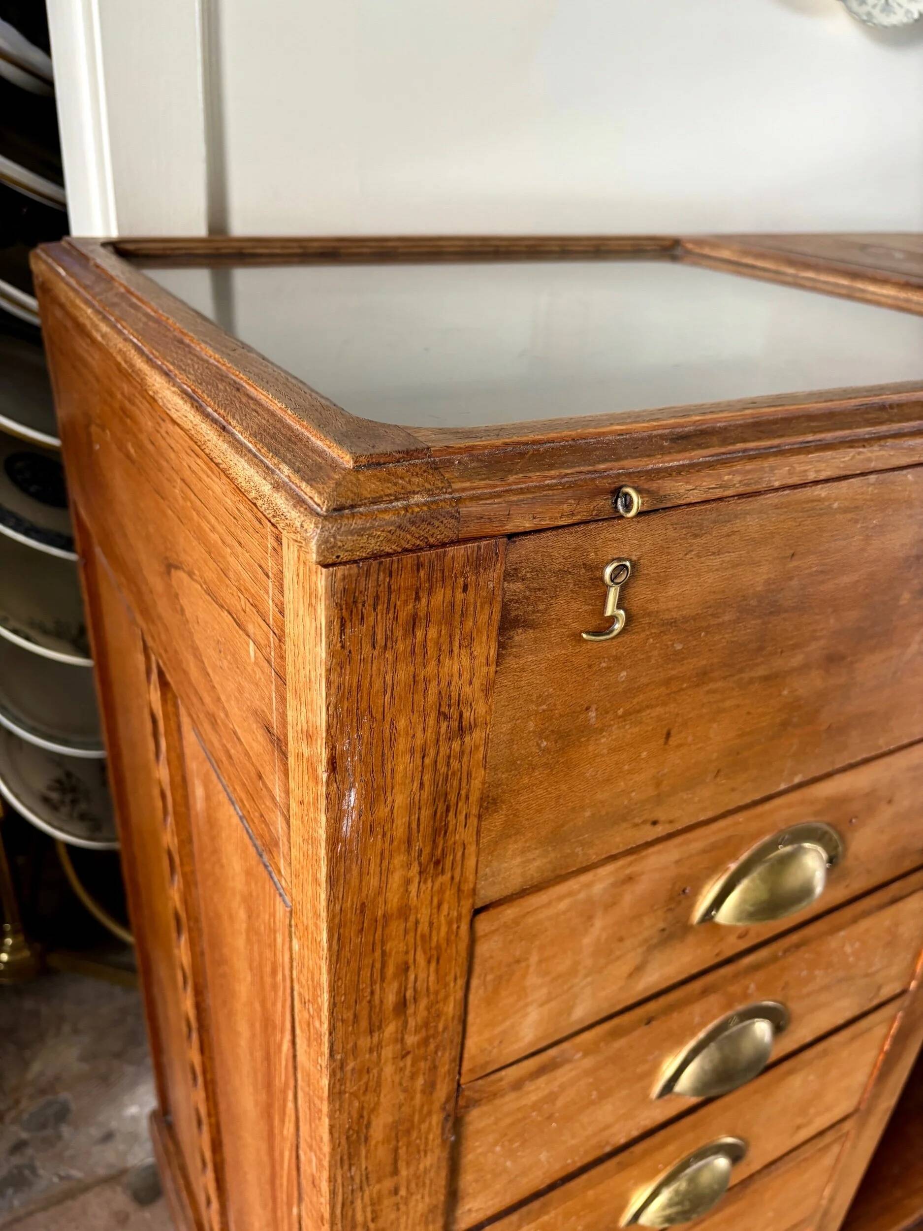 Counter, glass-fronted wooden workbench in dark wood, 8 drawers.