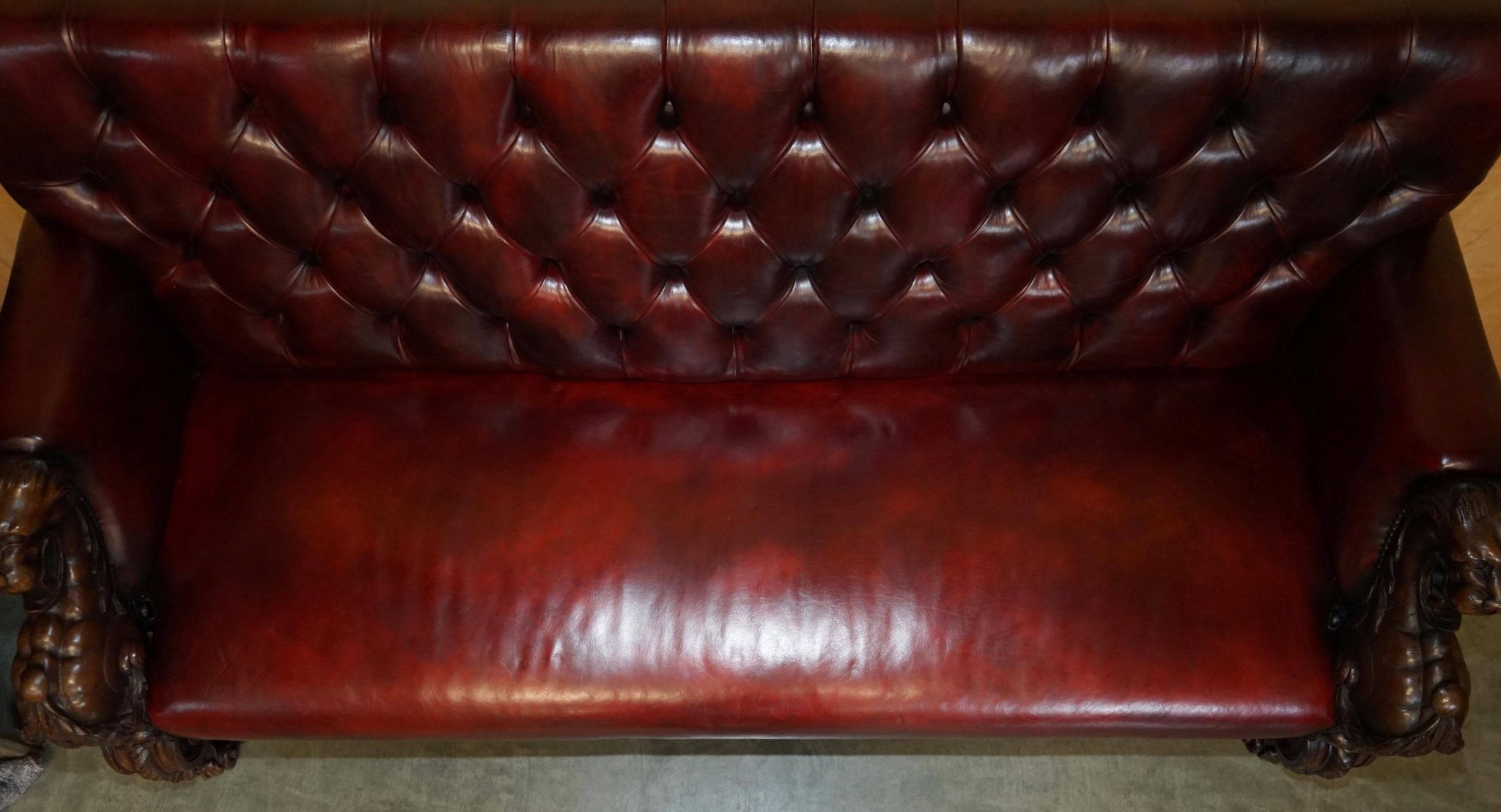 Victorian Chesterfield leather sofa with carved lion heads.