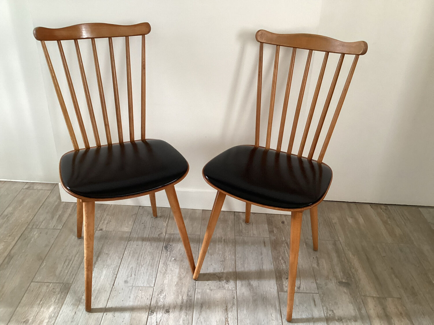 2 baumann chairs seated in imitation black leather