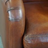 Cognac-colored sheepskin armchair with rounded shapes