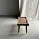 Brown Indonesian teak coffee table, with a border and cylindrical legs H40 L103.