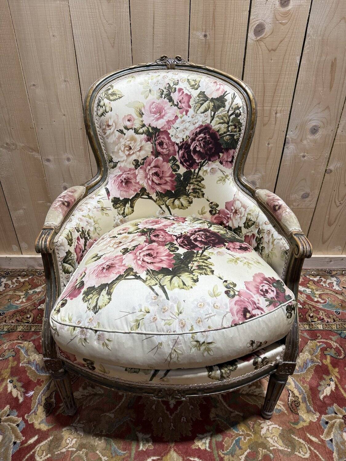 Reupholstered bergère with floral fabric in Louis XVI style.