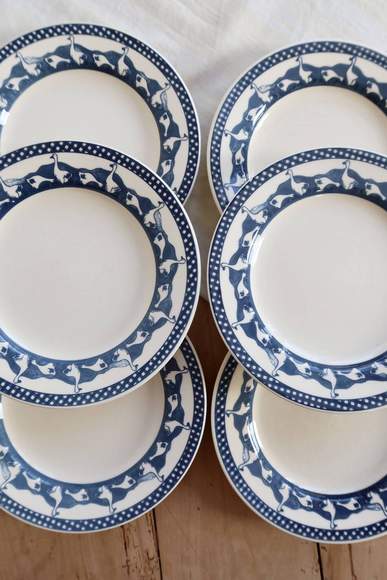 6 vintage flat plates with a blue and white goose pattern.