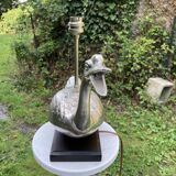 Old vintage lamp representing a duck in silver metal with wooden base