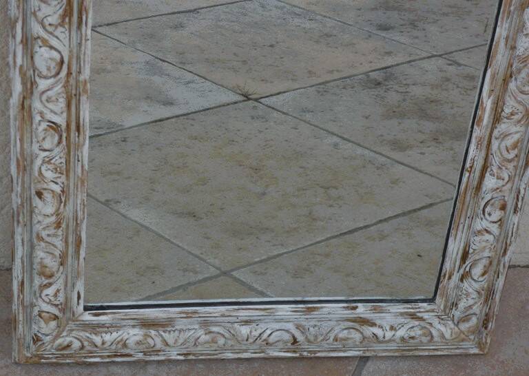 Chic and stylish antique mirror with carved wooden frame in whitewashed