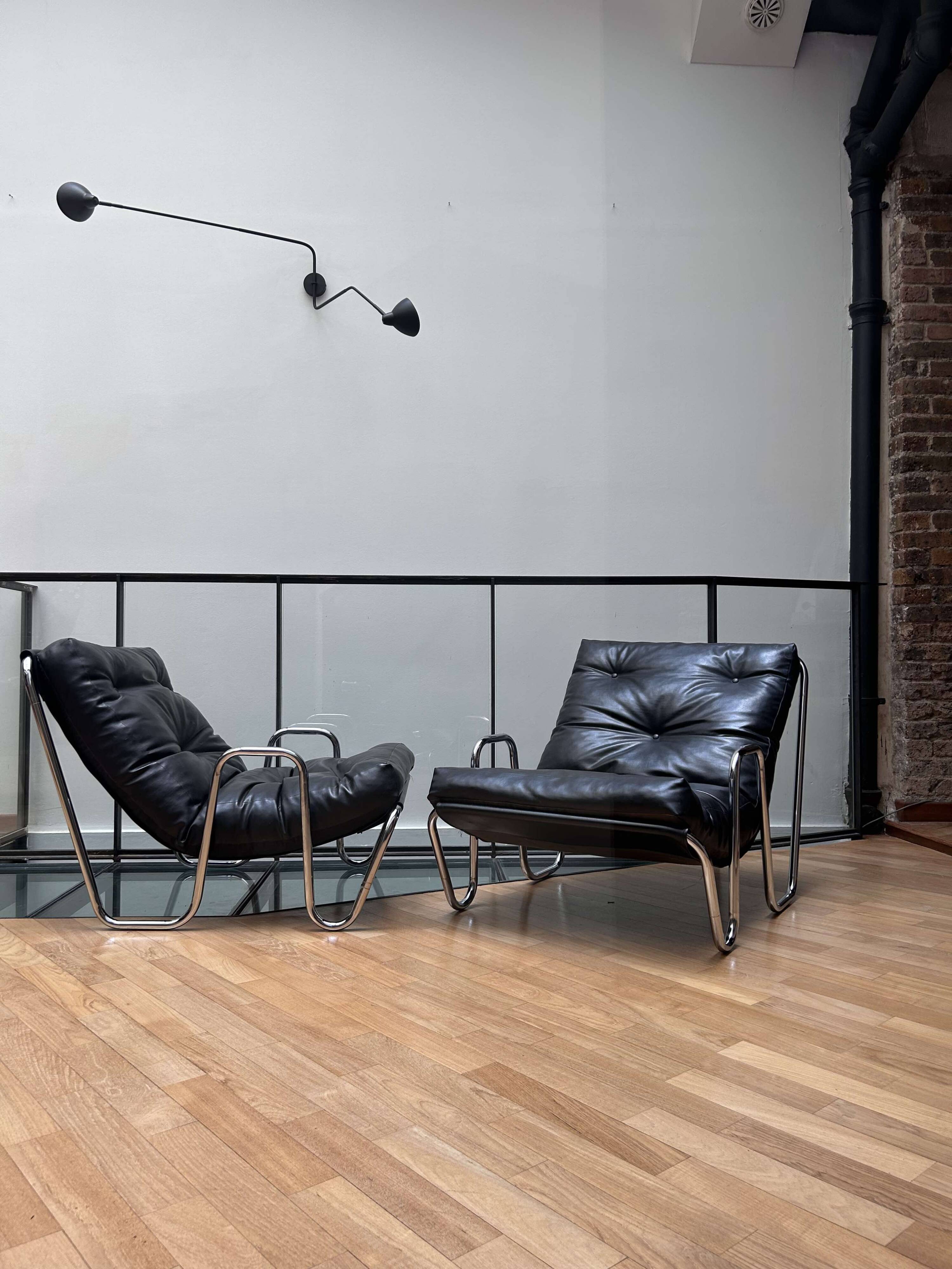 Pair of vintage armchairs in black imitation leather and chrome metal, France 1970