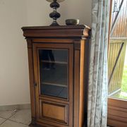 Small glass-fronted accent cabinet in cherry wood.