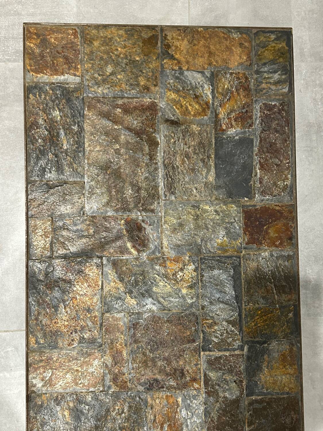 Brutalist-style coffee table made of mixed wrought iron and stone.