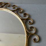 Round mirror with golden metal arabesques