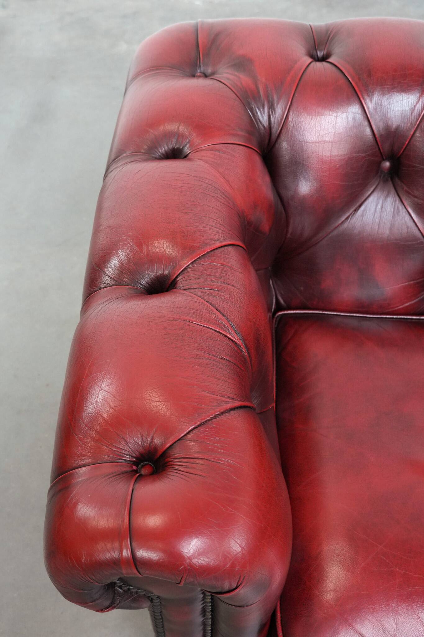 Red English cowhide Chesterfield armchair finished with decorative nails