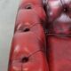 Red English cowhide Chesterfield armchair finished with decorative nails