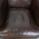 Dark brown vintage club armchair in English style made of sheepskin leather