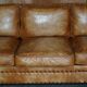 Three-seater leather canapé in Edwardian style with studs.