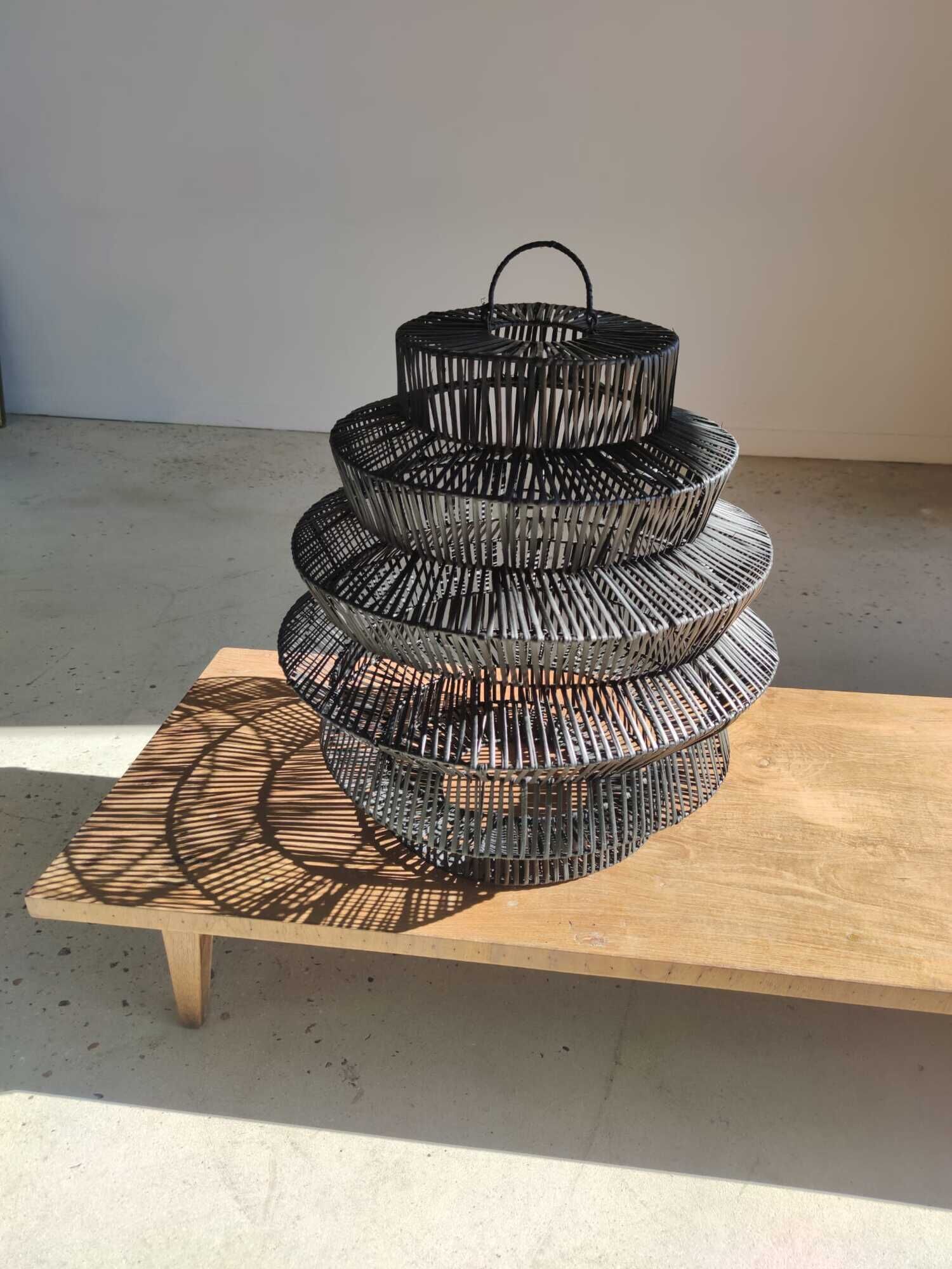Braided rattan suspension in the shape of a black accordion