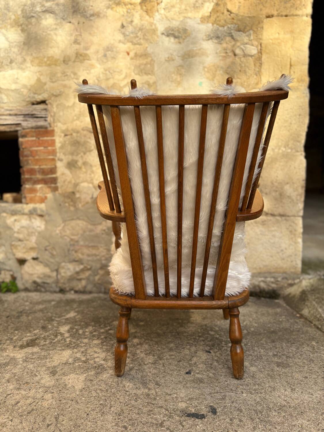 Scandinavian armchair in solid wood with beige fur cushion