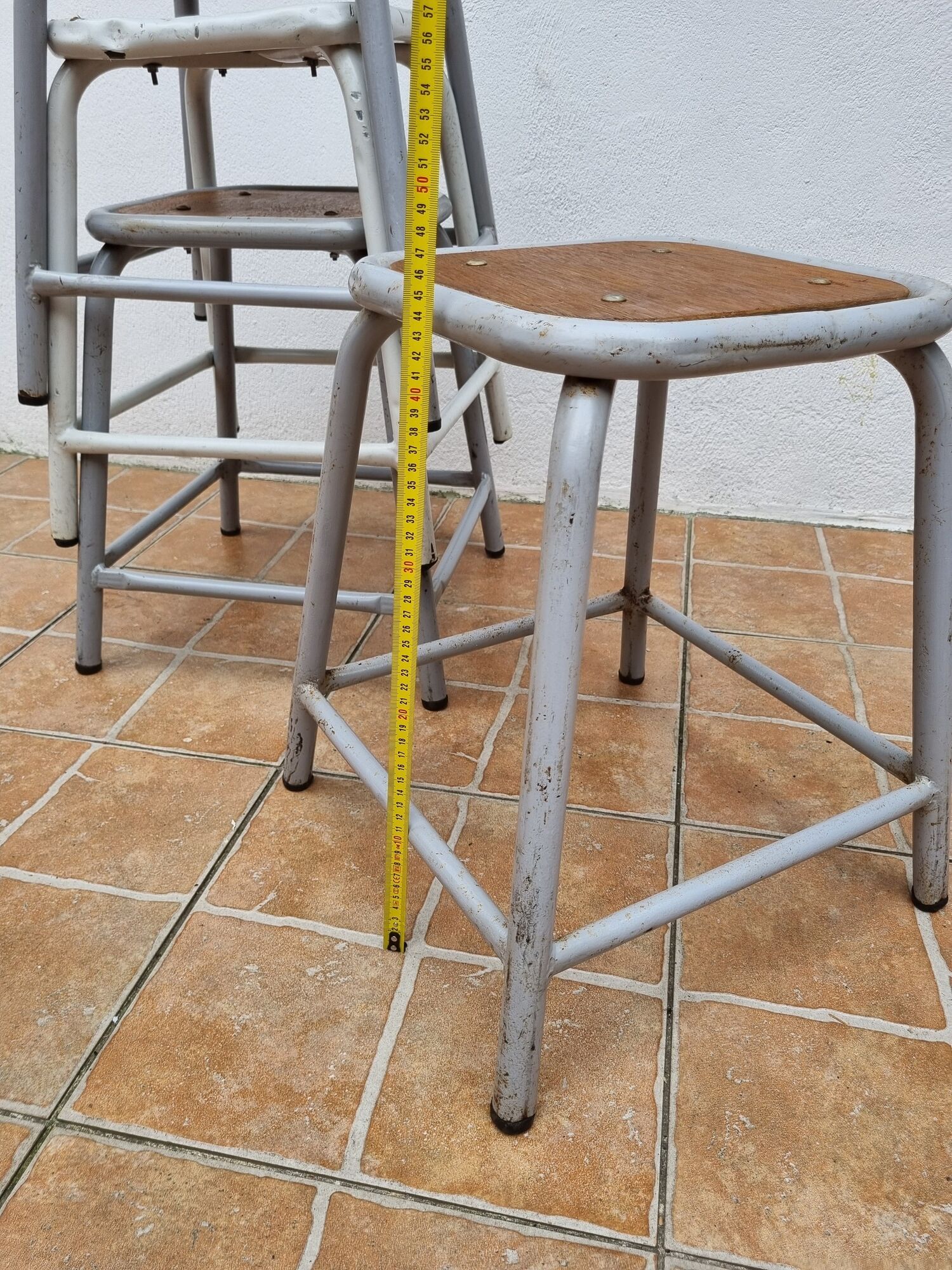 Set of four stackable industrial tubular metal and wood stools