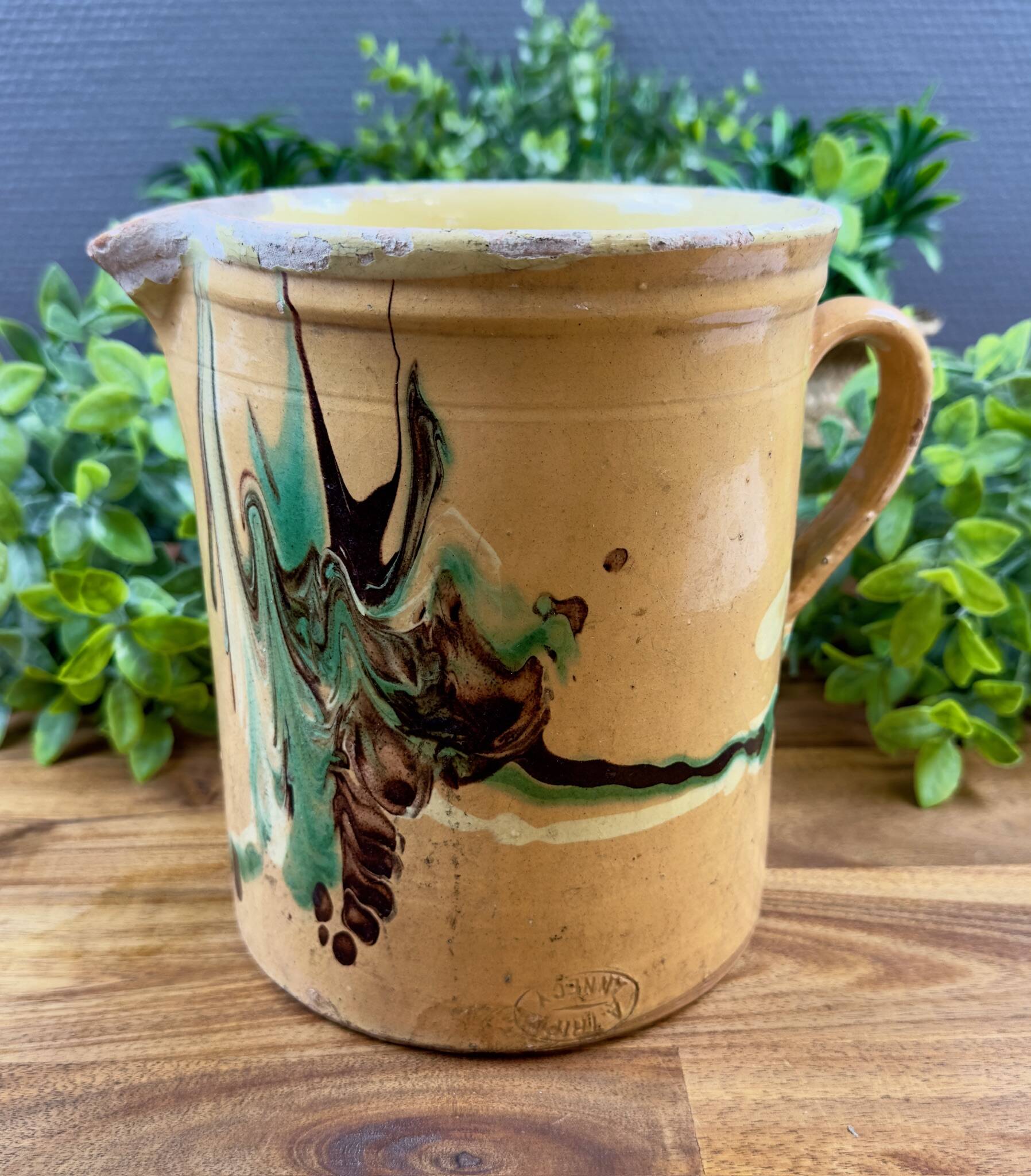 Large vintage ceramic pitcher with abstract green and brown decoration.