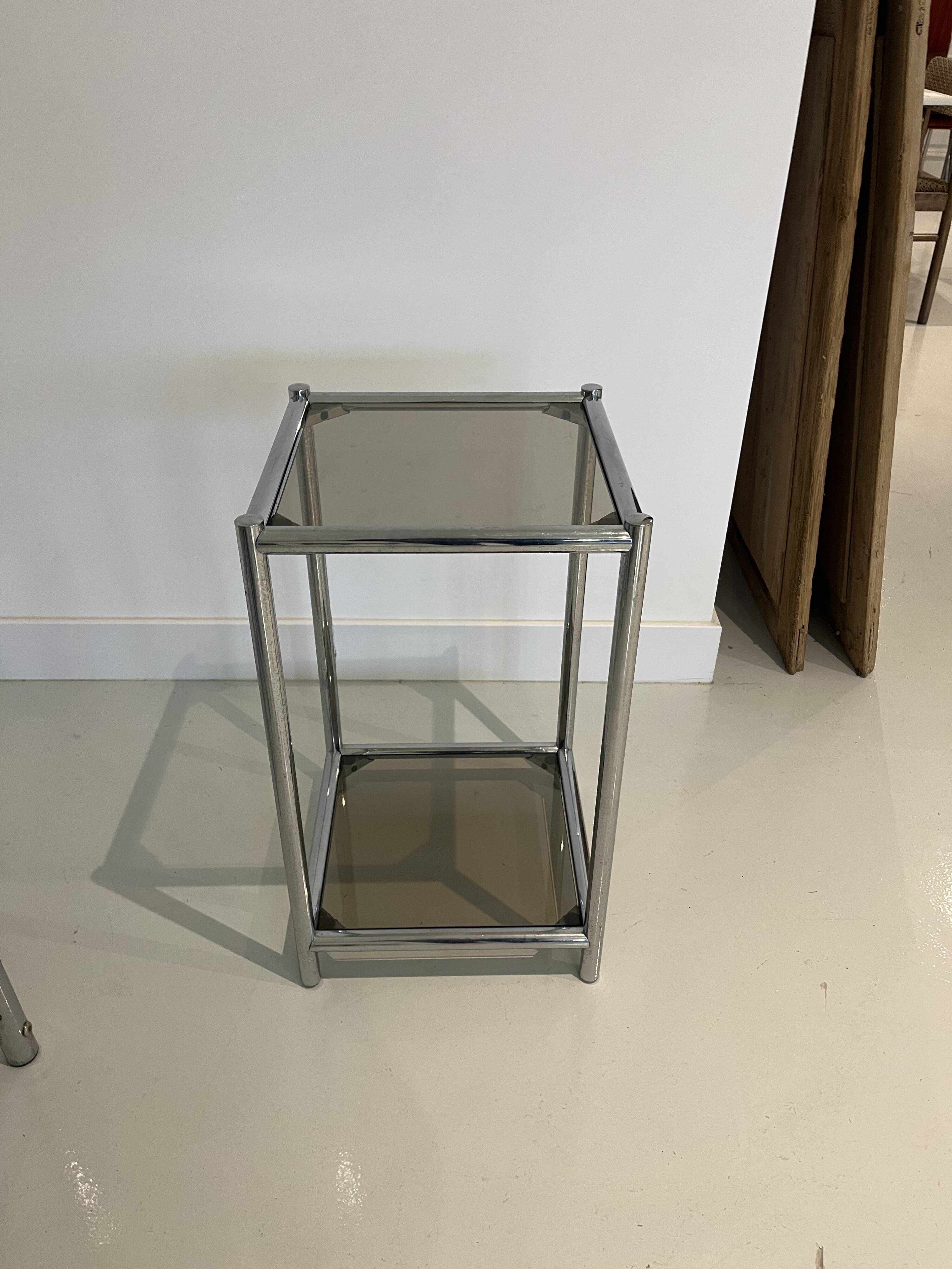 Bolster or end table in chrome steel with smoked window.