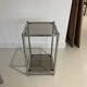 Bolster or end table in chrome steel with smoked window.