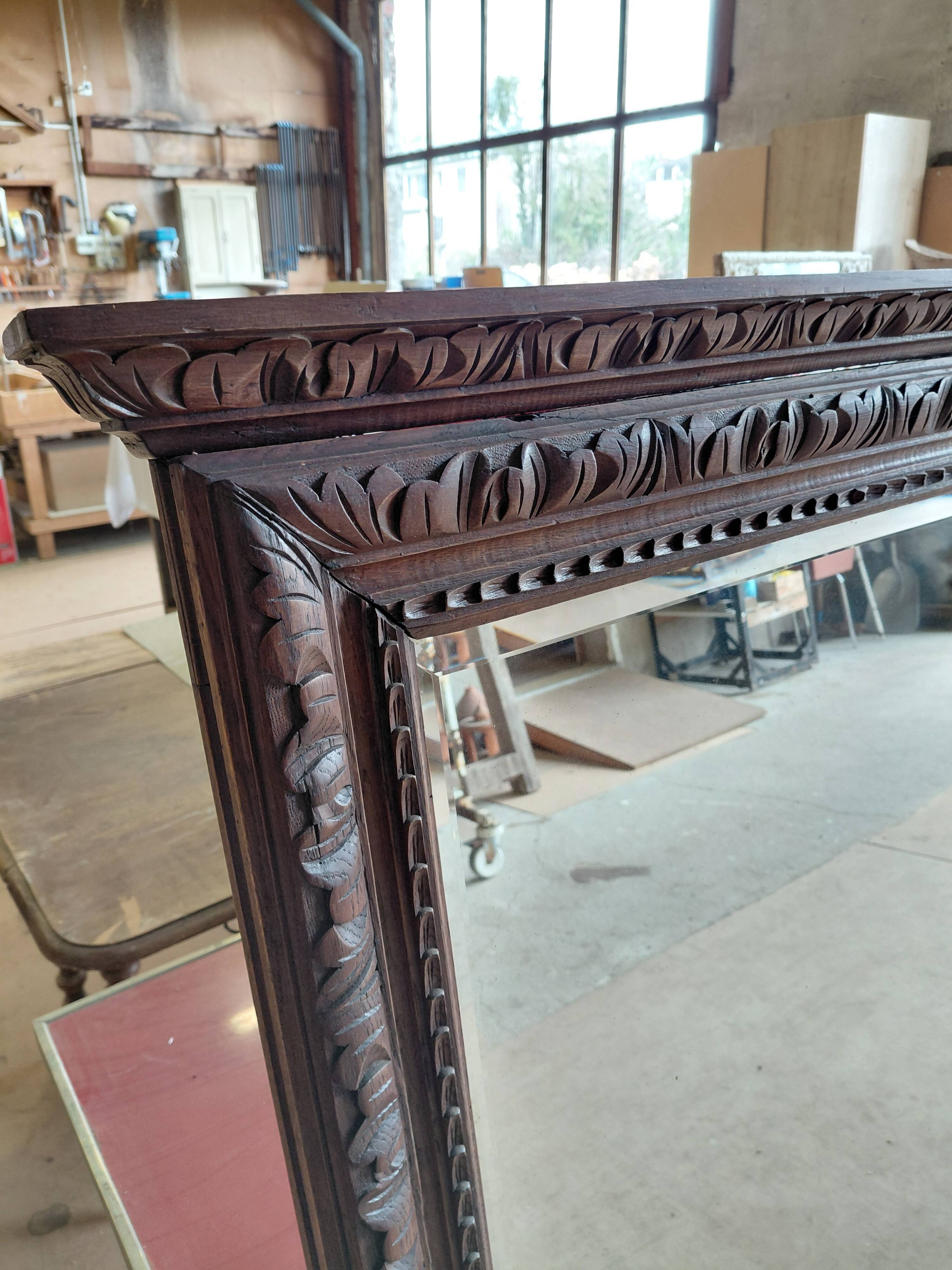 Large bevelled mirror with a carved wooden frame