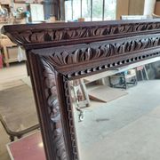 Large bevelled mirror with a carved wooden frame