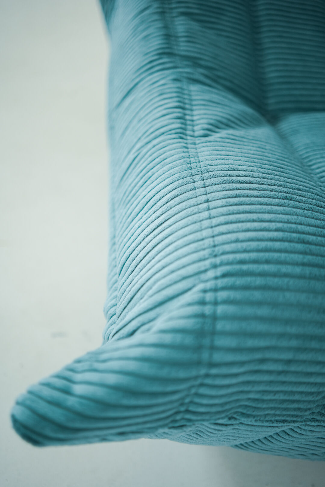 Ensemble de fauteuil et pouf Togo en velours côtelé bleu clair.